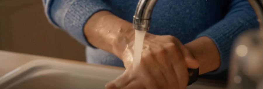 Hands washing under a faucet while wearing SilverKin