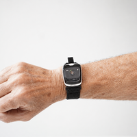 A close-up of a person's wrist wearing a SilverKin Tempo with a black mesh band, set against a plain light gray background.