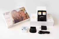 Silver Kin care kit shown with its retail box, white electronic device, black charging dock, black wall charger, and cable on a clean white background.