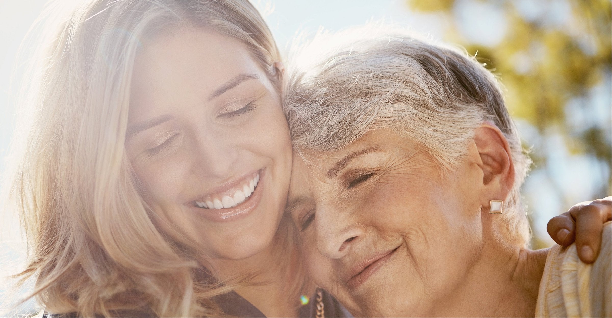 An adult daughter and her mother sharing a hug